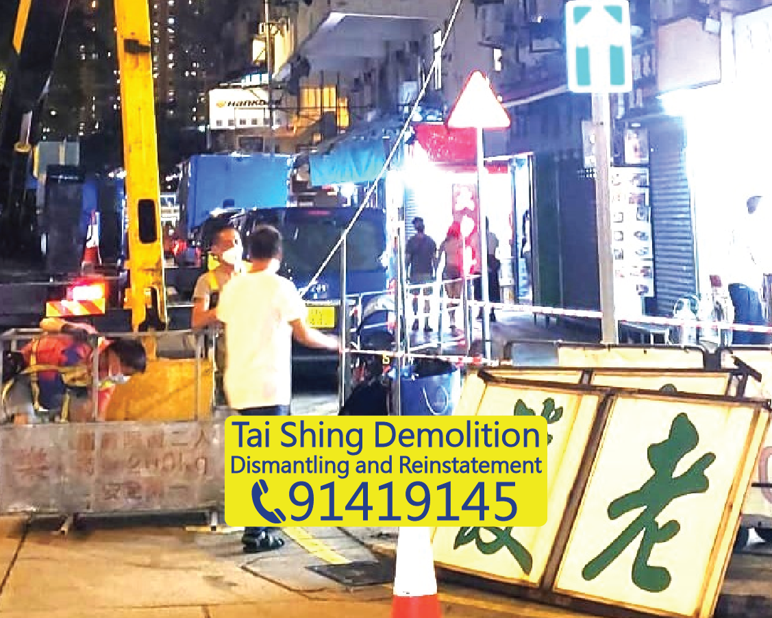 Ground clearing after signboard removal, large outdoor signboard components safely lowered, nighttime demolition project, Tai Shing Demolition